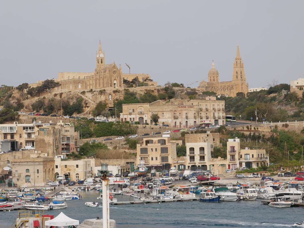 Gozo - prístav Mgarr, Kostol Panny Márie Lurdskej vľavo, Ghajnsielem Parish Church vpravo